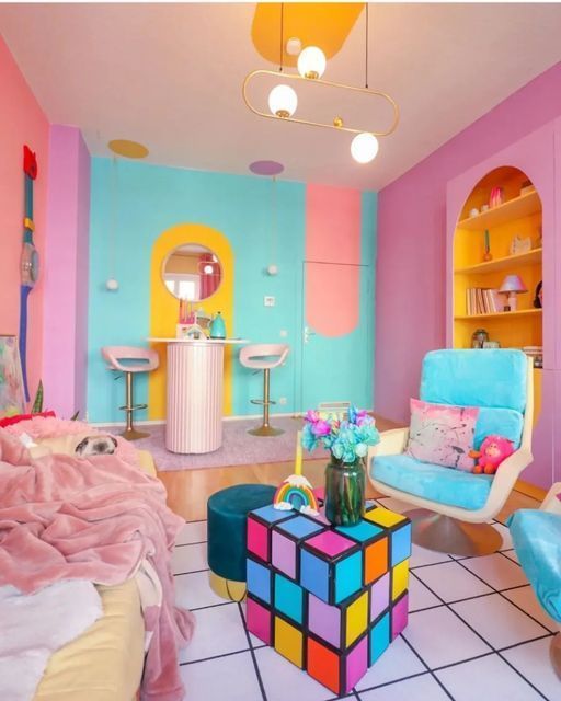 a dopamine decor living room with pink, coral and turquoise walls, a sofa, pink blankets, a blue chair and a fun coffee table