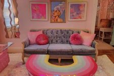 a dopamine living room with blush walls, a grey sofa with pink pillows, neon lights and a bright gallery wall
