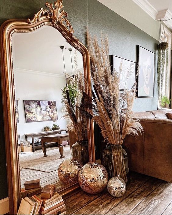a floor mirror in a chic vintage frame, with pampas grass and disco balls on the floor are a lovely combo for any space