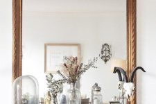 a large mirror over the mantel, with jars, vases and cloches and some other decor are a lovely combo