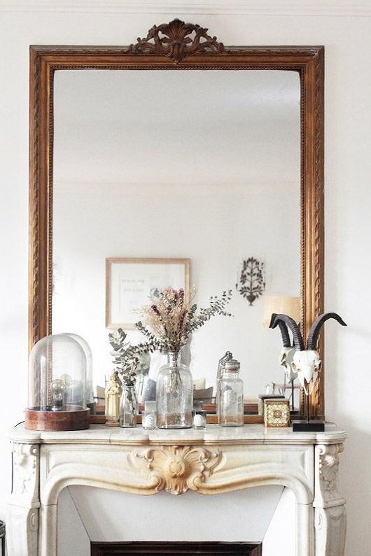 a large mirror over the mantel, with jars, vases and cloches and some other decor are a lovely combo