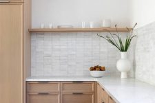 a light-stained oak kitchen with white countertops, an open shelf and a stacked tile backsplash is cool