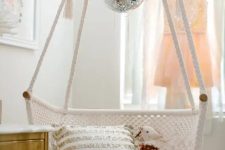 a macrame hammock chair with a disco ball for an accent are a lovely combo for a boho space, it’s shiny and cool