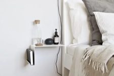 a minimal metal sheet nightstand attached to the wall is a perfect addition to a Scandinavian space