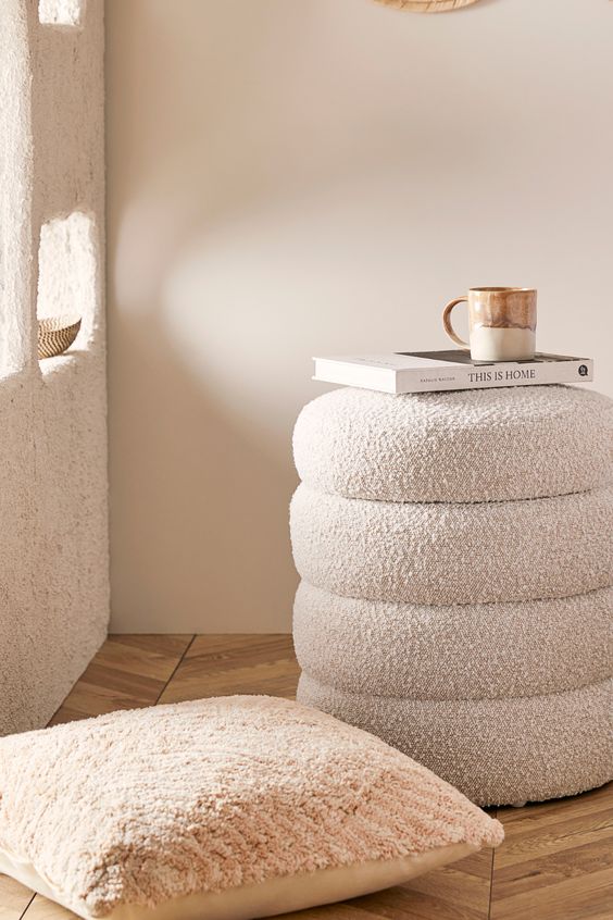a neutral boucle pouf with a storage space inside is a cool idea for a neutral space, it will fit many rooms