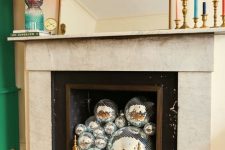 a non-working fireplace can be filled with silver disco balls to make it look chic and coo and add a fun accent to the space