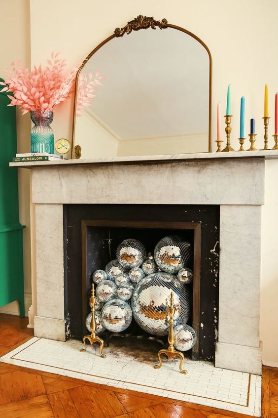 A non working fireplace can be filled with silver disco balls to make it look chic and coo and add a fun accent to the space