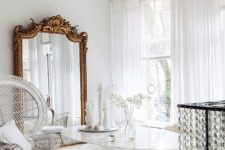 a refined dining space with a glass table, catchy and mismatching chairs, a huge mirror in a refined gilded frame