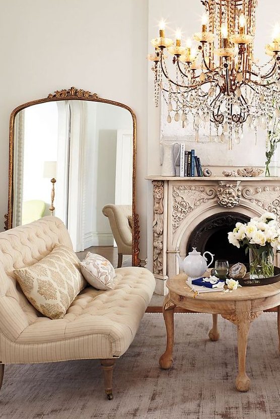 a refined vintage living room with an ornated fireplace, exquisite furniture, an oversized mirror in a gilded frame and a chic chandelier