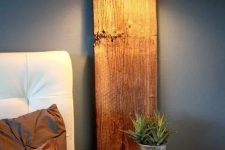 a rough wooden plank with a lamp and a surface to hold your things is a cool idea for a rustic bedroom