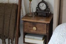 a small dark-stained floating nightstand with a vintage knob is a chic and elegant solution for a tiny bedroom