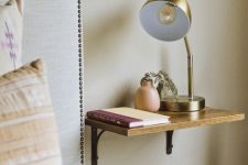 a small shelf as a nightstand with a vase, a book and a lamp is all you need for a small bedroom