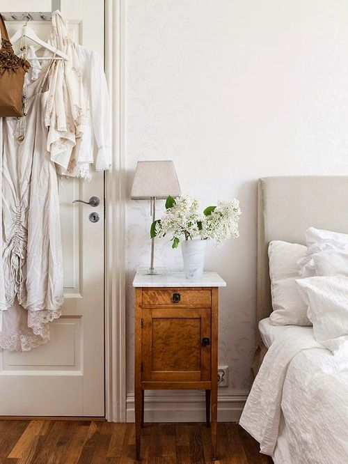 a small stained nightstand with a drawer and a storage compartment and a white stone countertop for more elegance