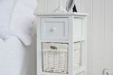 a small white coastal nightstand wih a drawer and baskets is a lovely idea for a vintage coastal home