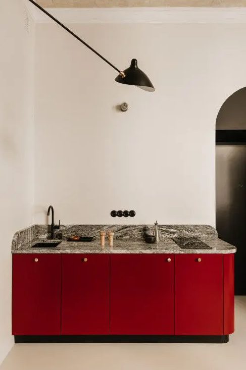 a small yet refined burgundy kitchen with a grey stone countertop and black details is a lovely and bold solution