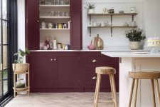 a sophisticated burgundy to purple kitchen with open shelves, a white kitchen island and wooden stools