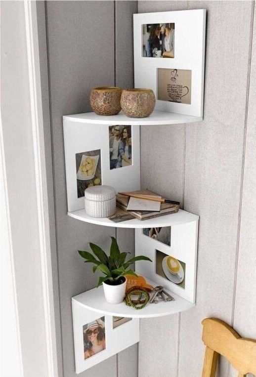 a stylish and creative corner shelving unit with photos, decor, candles and a potted plant is a cool way to style a small corner