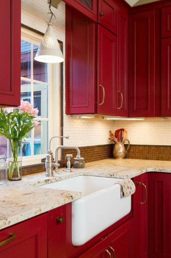 a super bold red vintage kitchen with two types of tiles on the backsplash and stone countertops looks very chic and elegant
