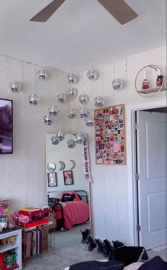 a teen room with a floor mirror in the corner and a whole arrangement of silver disco balls for a bit of fun and light