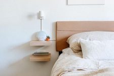 a tiny floating nightstand of two shelves looks minimalist and laconic and gives you storage space