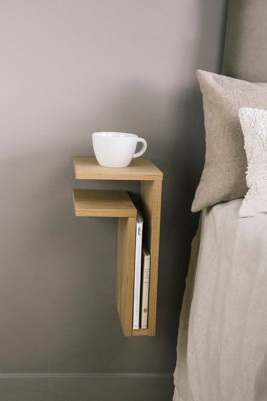 A tiny wall mounted shelf nightstand will be enough for books and a cup or a glass of water, it's a cool idea for a small bedroom