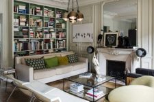 an eclectic Parisian chic living room with a fireplace, built-in shelves, neutral seating furniture, a coffee table and lamps