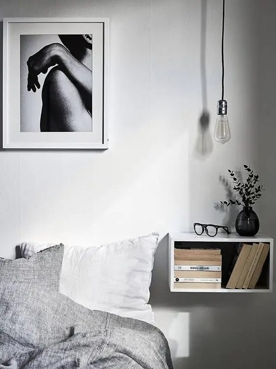 an open white box floating nightstand has a storage space inside and a top to place something
