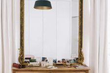 an oversized mirror in a refined frame with detailing is a beautiful solution for any space, from an entryway to a bedroom