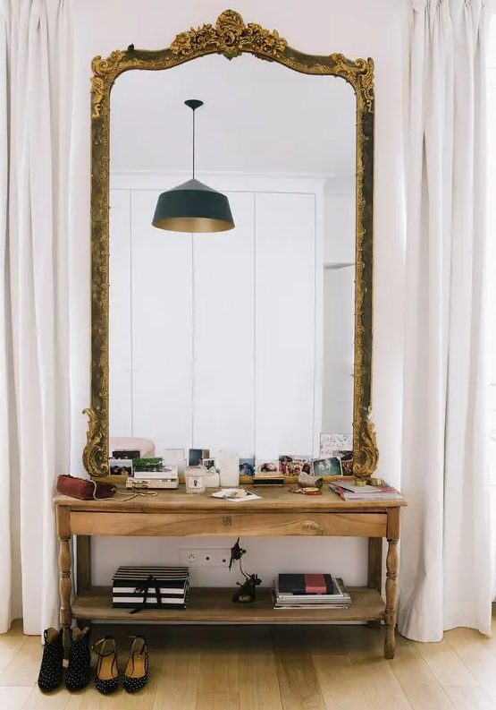 an oversized mirror in a refined frame with detailing is a beautiful solution for any space, from an entryway to a bedroom