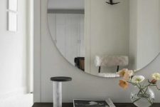 an oversized round mirror with no frame is a bold and modern statement for your entryway