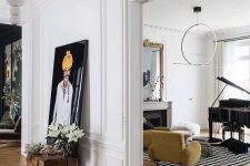 bold and contrasting spaces with chevron floors and molding, a fireplace, yellow seating furniture, some decor and artwork