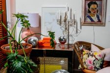 bright and whimsical decor with a credenza, a candelabra, a neon sign, a disco ball and a potted plant plus bright pillows