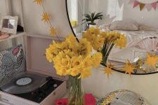 bright console table decor wiht bold blooms, books, a disco bal and a vinyl record player are a lovely and stylish combo
