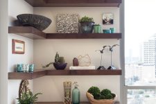 dark-stained corner shelves contrast neutral walls and show off a lot of beautiful and refined decor and potted plants