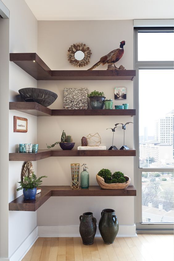 Dark stained corner shelves contrast neutral walls and show off a lot of beautiful and refined decor and potted plants