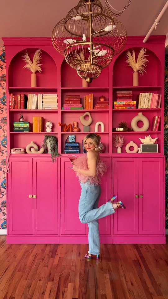 extra bold hot pink arched bookcases and cabinets with books and decor are a gorgeous solution for any maximalist space