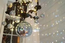 hang disco balls on a usual chandlier to cheer up the space and a bring a timeless party feel to the space at once