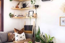 light-stained corner shelves with decor and potted plants are a cohesive part of this boho living room