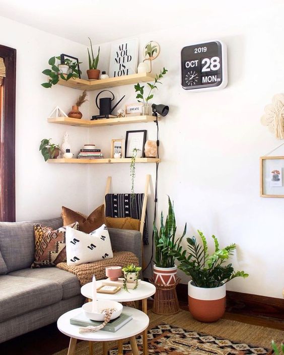 Light stained corner shelves with decor and potted plants are a cohesive part of this boho living room