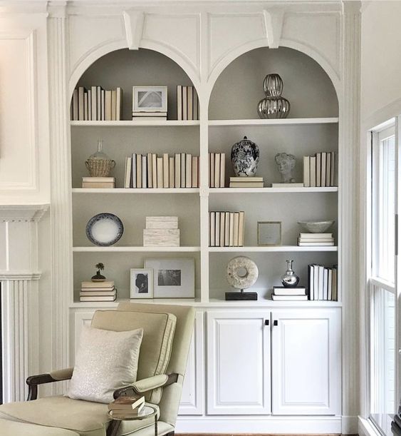 Neutral built in arched bookcases with such molding are a very chic and cool solution for a neutral and refined space