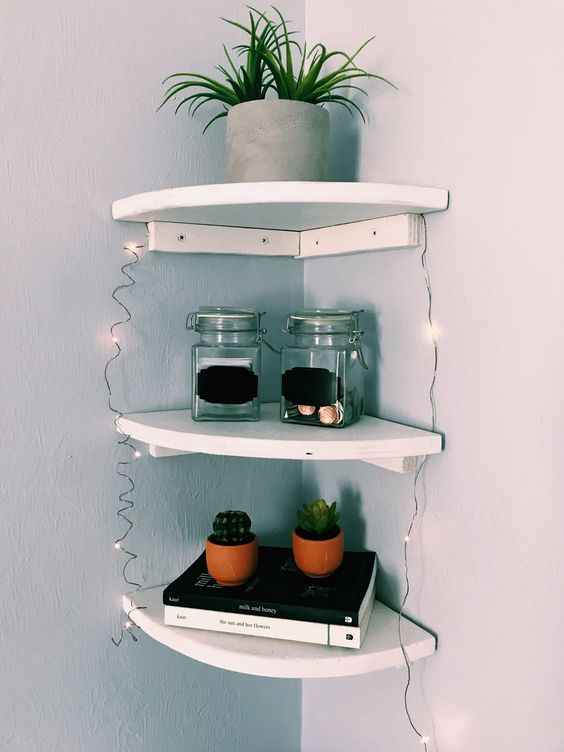 small rounded corner shelves with decor, potted plants and lights are amazing to use little corners in the room