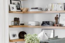 stained corner shelves add warmth to the space and stylish black and white decor and bowls add interest to it