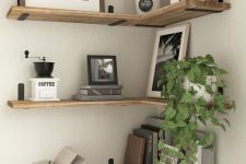 stained floating shelves with artwork, photos, books and potted plants are amazing to style a modern space
