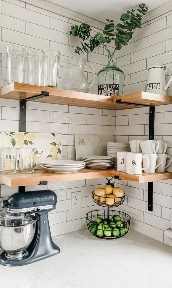 Wall mounted stained corner shelves with glasses and teaware are a perfect idea for a farmhouse space