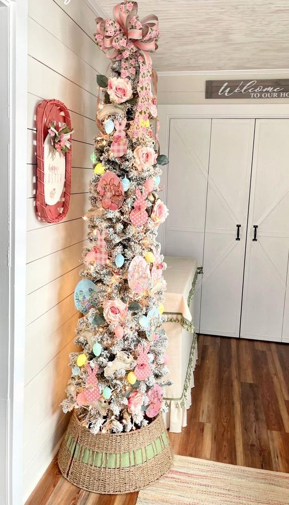 a Christmas tree styled for Eater with pink faux roses, pastel paper eggs, blooms, pastel plastic eggs and a bow on top