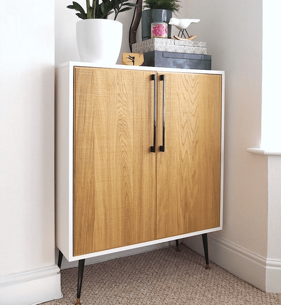 a Metod cabinet placed on legs and renovated with light-colored wooden doors and handles in mid-century modern style