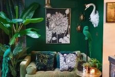 a bold living room with emerald walls, a muted green sofa, potted plants and a parrot figurine in emerald