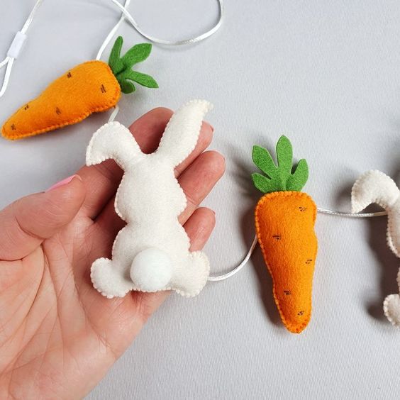 a bright felt garland of felt carrots adn bunnies is a cool idea for spring and Easter, it looks nice