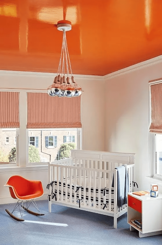 a bright orange ceiling, a matching chair and drawer to create a bold and welcoming kid’s room