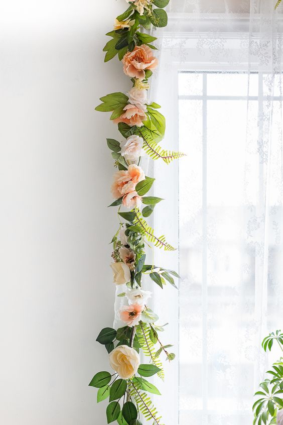 a chic and very natural-looking garland of faux blooms and greenery is a lovely decoration for spring and summer